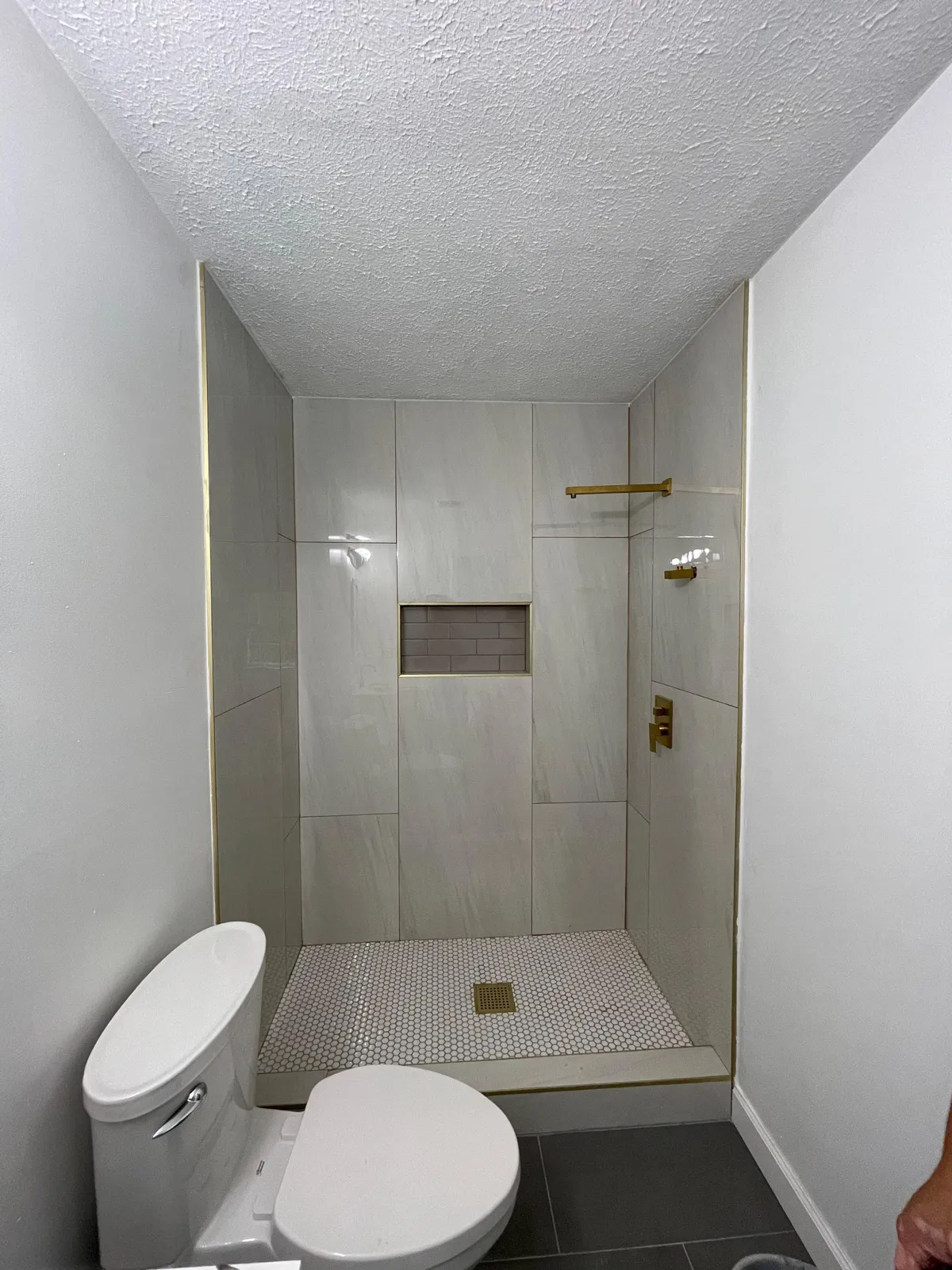 Modern bathroom with tiled walk-in shower and gold fixtures