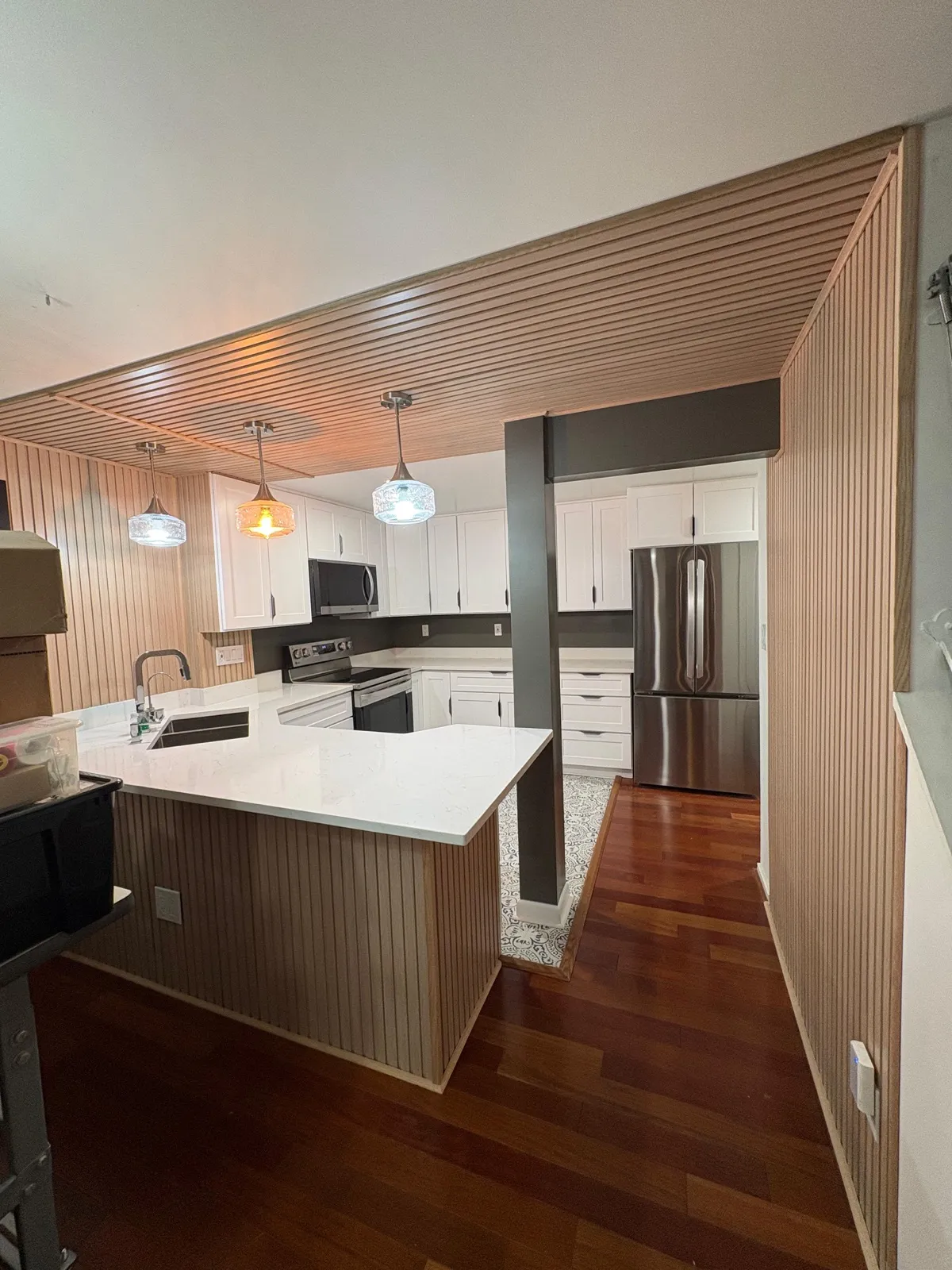 Modern kitchen with wood paneling and pendant lights
