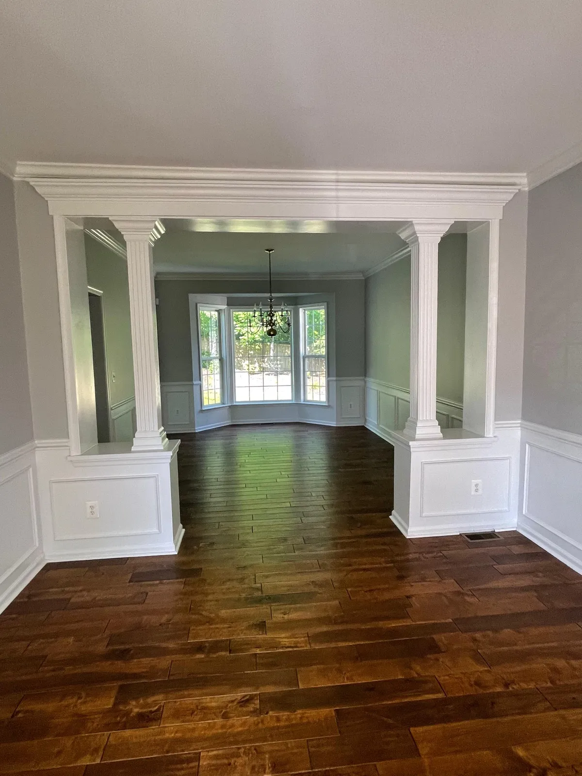 Formal dining room with columns and dark hardwood floors