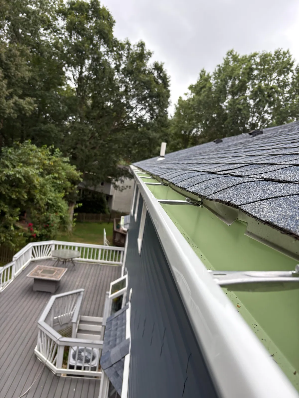 Asphalt shingle roof edge with seamless gutter