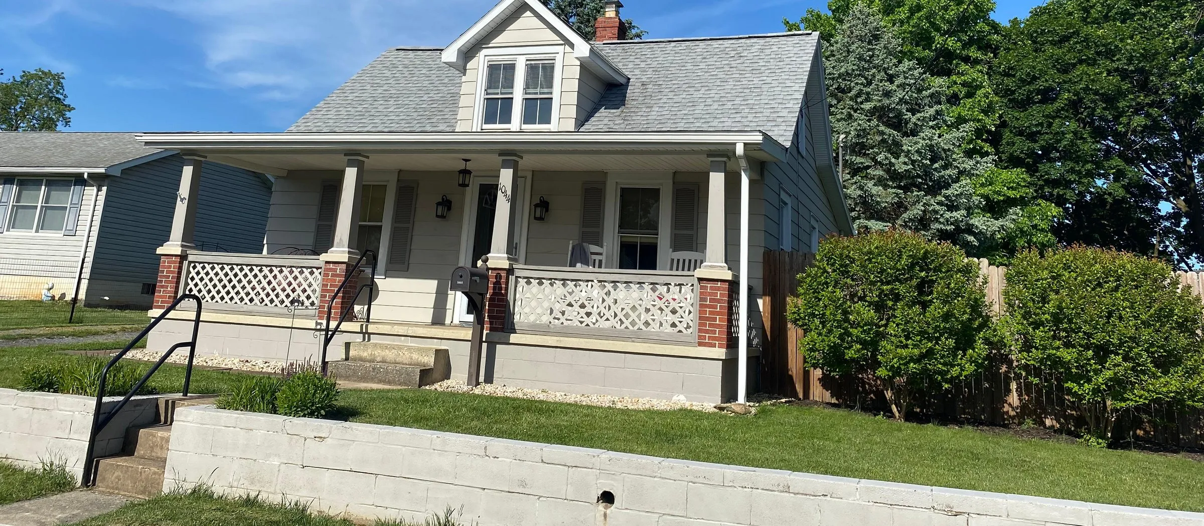Cape Cod home with a new gray architectural shingle roof and front porch