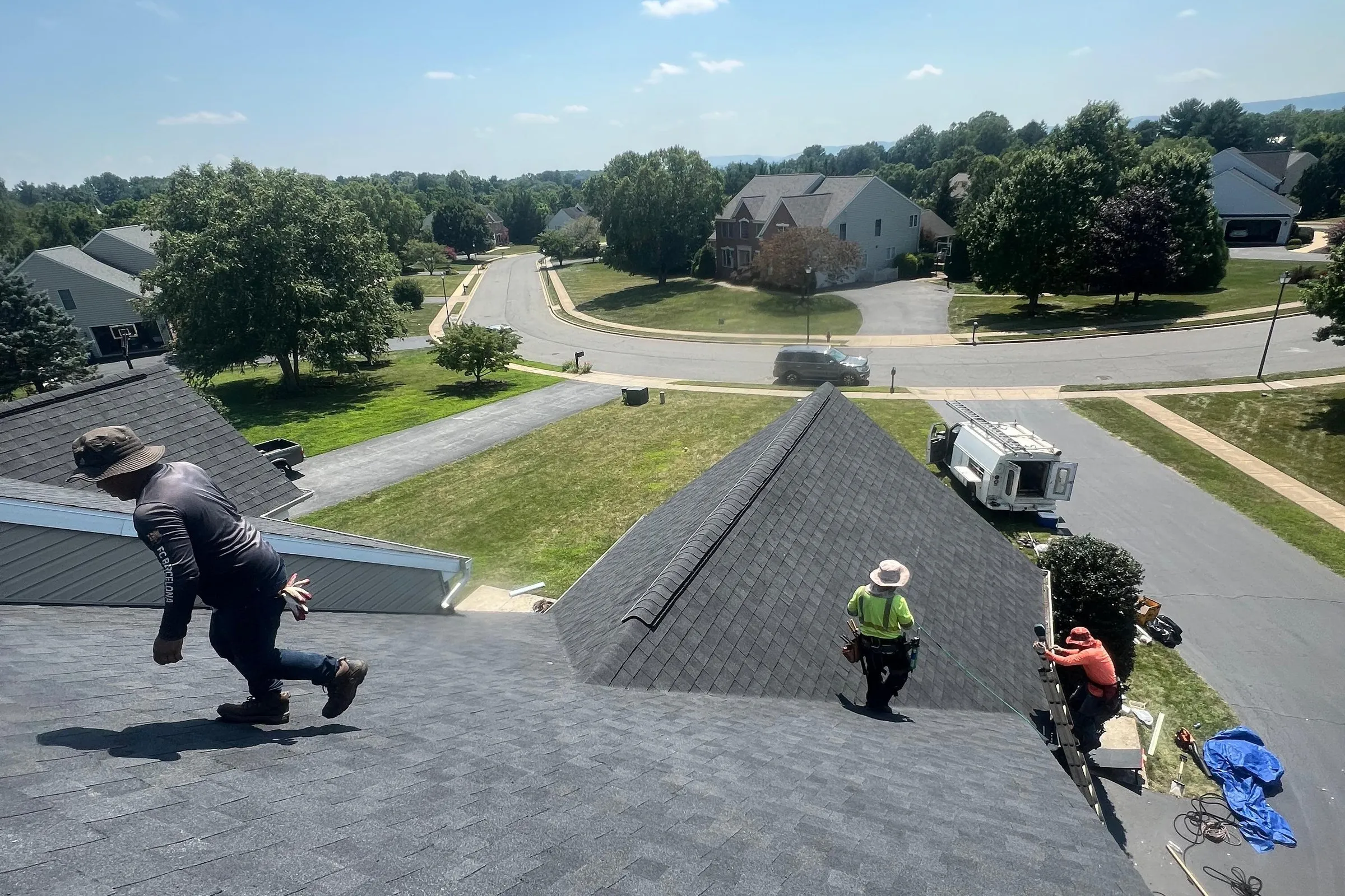 Our crew finishing a new gray architectural shingle roof on a suburban home